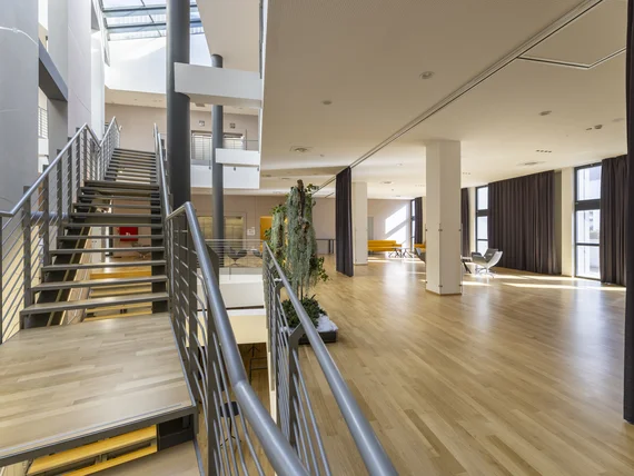 Interno moderno con scale in metallo e ampio spazio luminoso con pavimento in legno