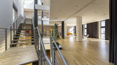 Interno moderno con scale in metallo e ampio spazio luminoso con pavimento in legno