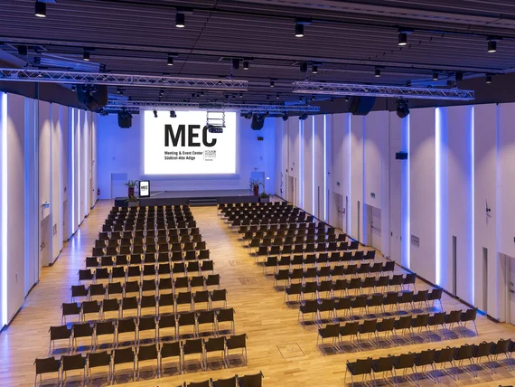 Sala conferenze moderna con sedie disposte in file e grande schermo MEC