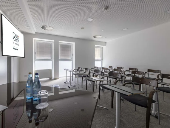 Sala conferenze vuota con sedie e tavoli al Four Points by Sheraton Bolzano Bozen