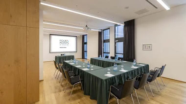 Sala riunioni con tavoli a ferro di cavallo e schermo proiettore al Four Points by Sheraton