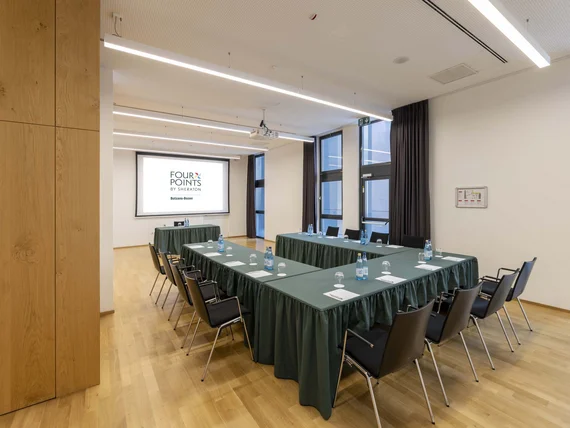 Sala riunioni con tavoli a ferro di cavallo e schermo proiettore al Four Points by Sheraton
