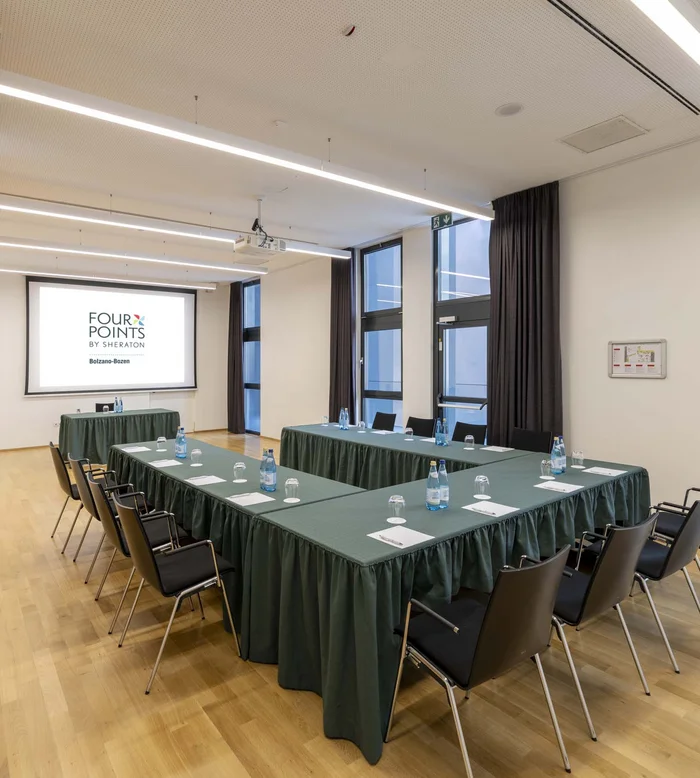 Sala riunioni con tavoli a ferro di cavallo e schermo proiettore al Four Points by Sheraton
