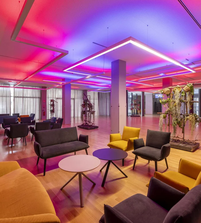 Salotto moderno con luci LED colorate e sedute arancioni e grigie