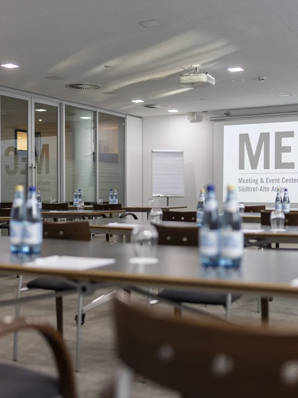 Conference room with tables, chairs, and water bottles ready for event