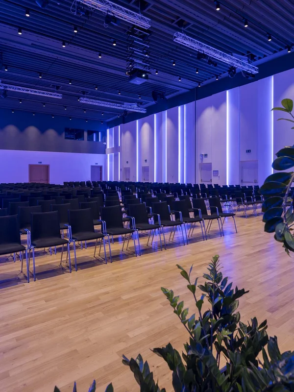 Sala conferenze moderna con sedie nere e illuminazione blu
